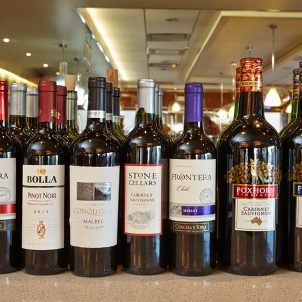 A selection of red wine bottles from various brands, including Bolla and Foxhorn Vineyard.