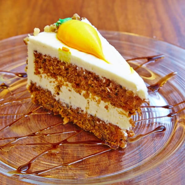 A slice of Jax Inn Diner's carrot cake with cream cheese frosting and a marzipan carrot.
