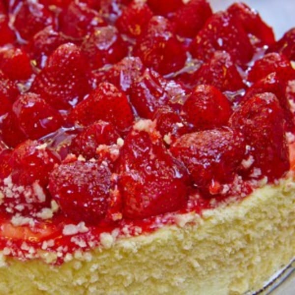 Close-up of a strawberry cheesecake with glistening red berries and a golden crust from Jax Inn Diner.